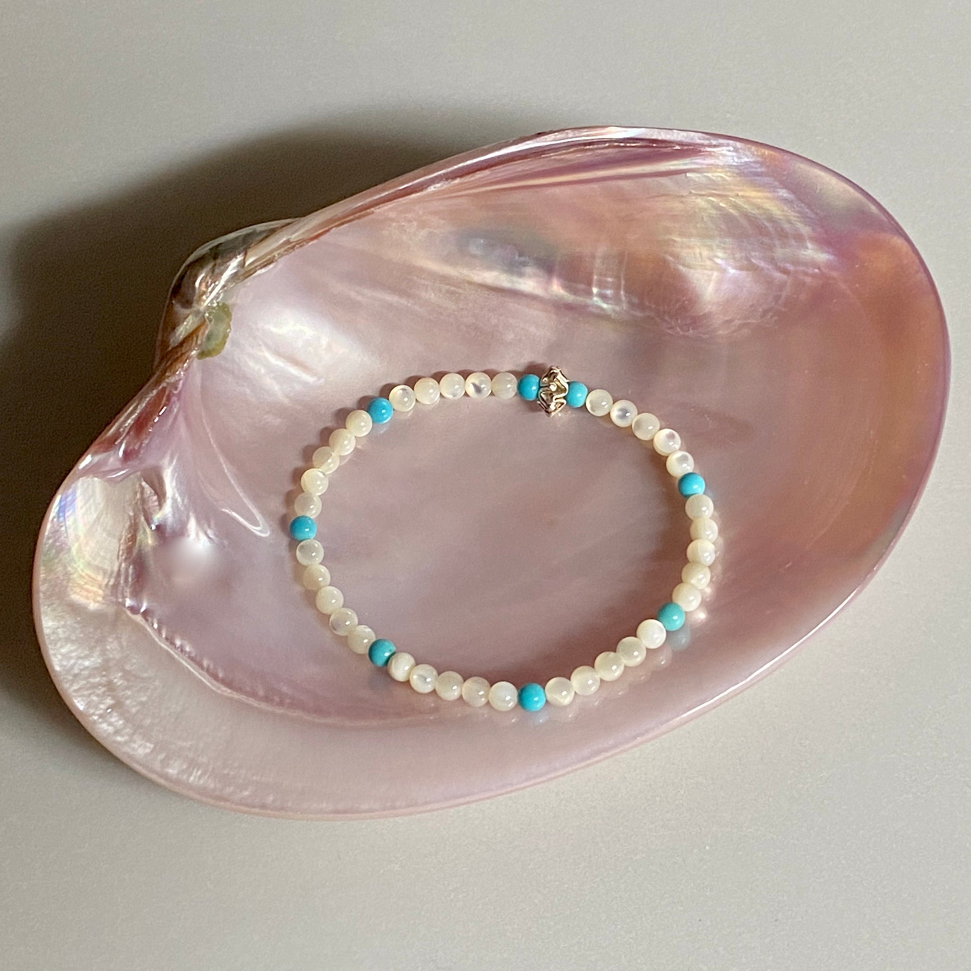 Between the Cominos white mother of pearl & sleeping beauty turquoise beachlove stretch bracelet by Kimberly Arpaia